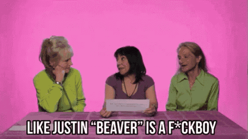 three women are sitting at a table and one of them says " like justin "