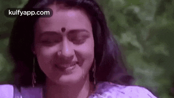 a close up of a woman with her eyes closed and a nose ring .
