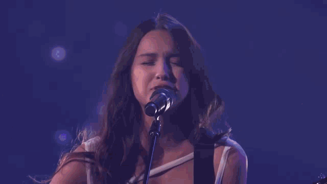 a group of women are playing guitars and singing on a stage