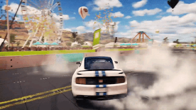 a white car with blue stripes on the side is drifting on a track