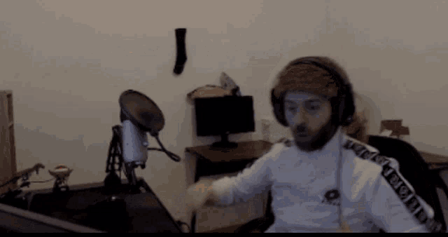 a man wearing headphones and a sweatshirt that says ' everton ' on the side