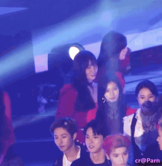 a group of people standing in front of a blue light with the hashtag cr @ parn on the bottom