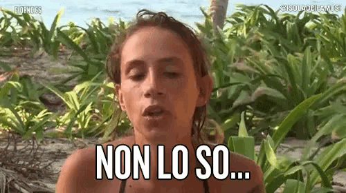 a woman in a bikini says non lo so in front of a lush green field .