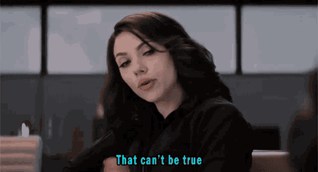 a woman sitting at a table with the words that can 't be true behind her