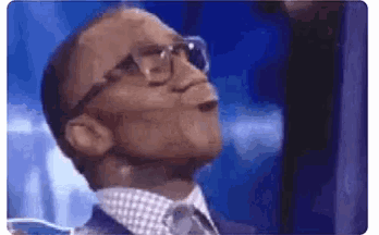a man wearing glasses and a suit and tie is looking up .