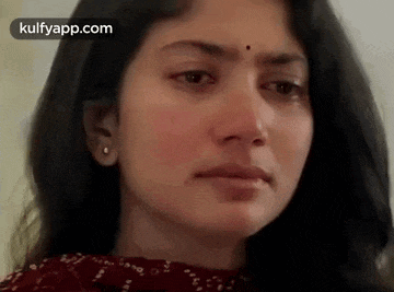 a close up of a woman 's face with a tear running down her face .