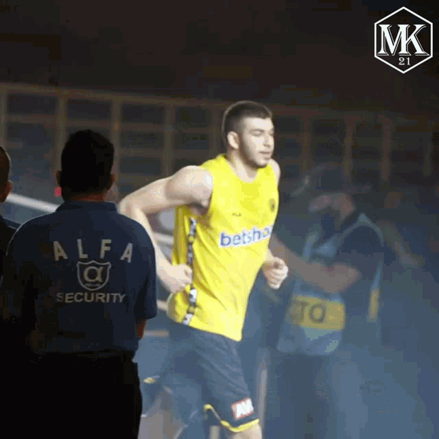 a man wearing a yellow shirt that says ' betsha ' on it