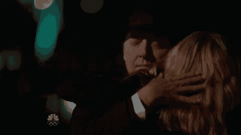 a man and a woman are hugging in the dark .