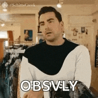 a man in a black and white sweater is standing in a clothing store and talking to someone .
