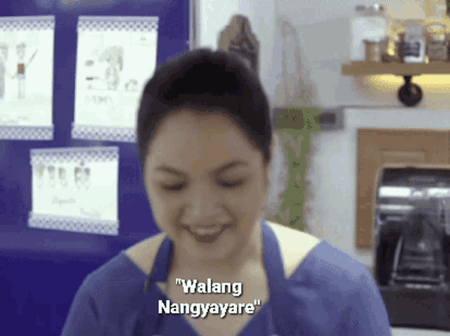 a woman in a blue apron is smiling and says " walang nangyayari "
