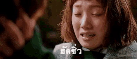 a woman is crying with her eyes closed and a man is behind her .