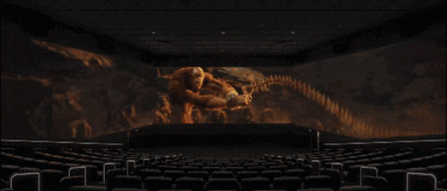 an empty movie theater with a large screen showing a fire