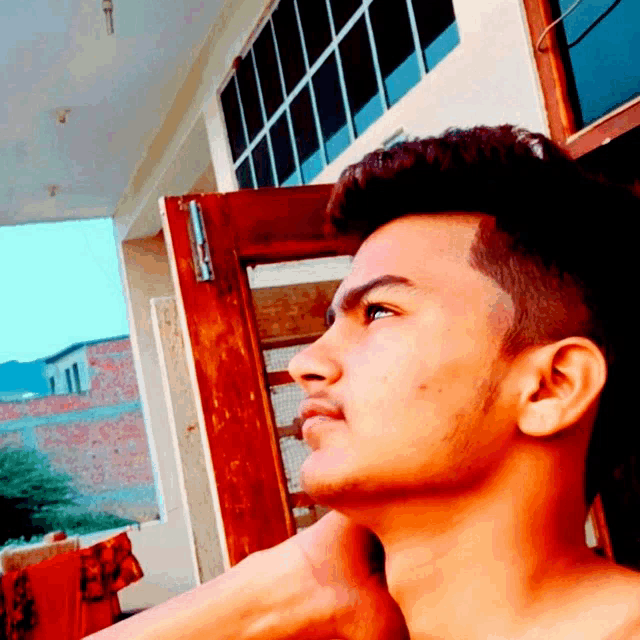 a young man with a beard is looking to the side