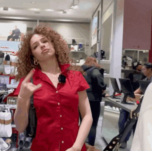 a woman in a red shirt giving the middle finger in a store