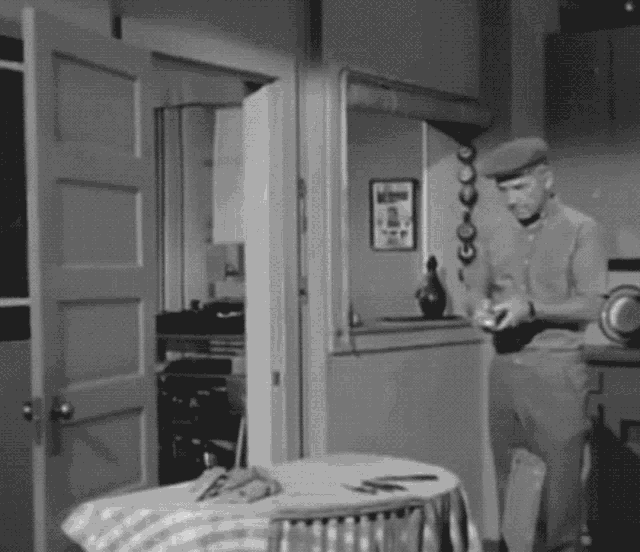 a black and white photo of a man standing in a room