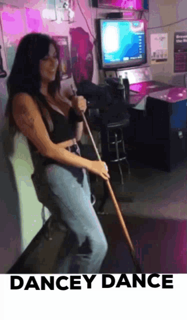 a woman is holding a pool cue and the words dancey dance are on the bottom