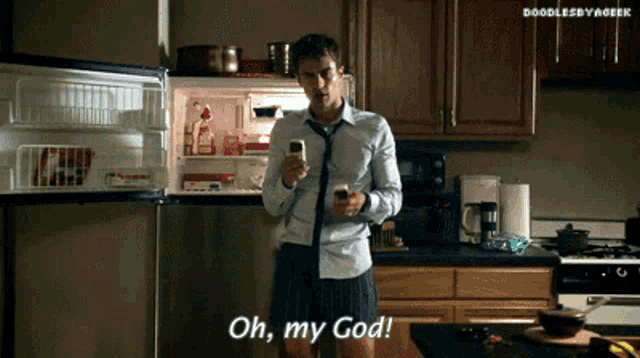 a man standing in a kitchen looking at his phone with the words oh my god written below him
