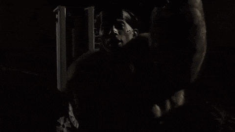 a black and white photo of a group of people dancing in the dark .