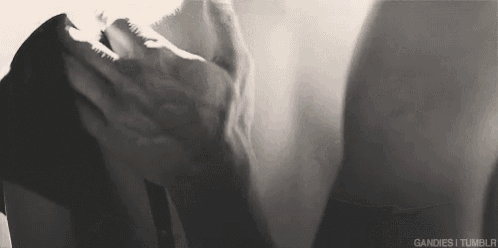 it is a black and white photo of a man holding a woman 's arm .