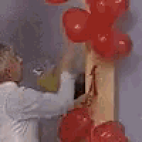 a woman is painting a picture on a wall with a brush .