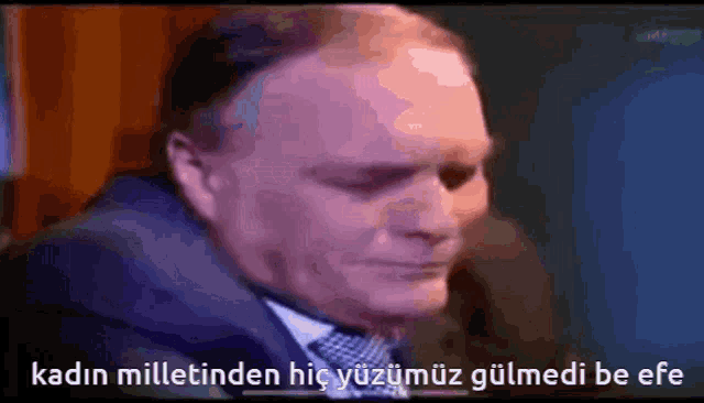 a man in a suit and tie with the words " kadin milletinden hic yüzümüz gülmedi be efe " on the bottom