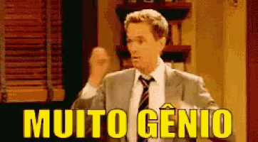 a man in a suit and tie is standing in front of a sign that reads muito genio