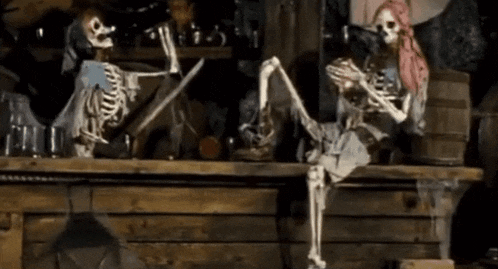 a couple of skeletons are sitting on a table