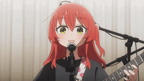 a girl with red hair is singing into a microphone while playing a guitar