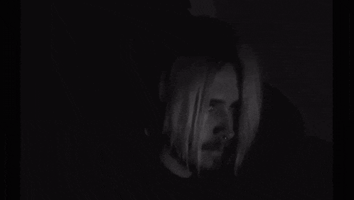 a black and white photo of a man with long blonde hair and a beard .
