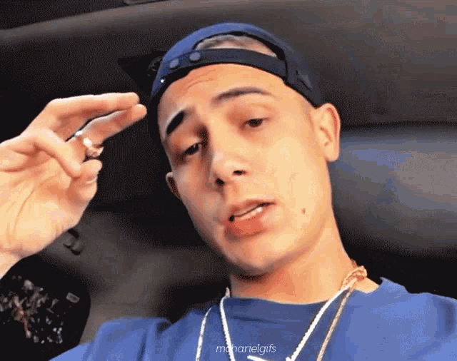a man wearing a baseball cap and a blue shirt has the name manarielgif on the bottom