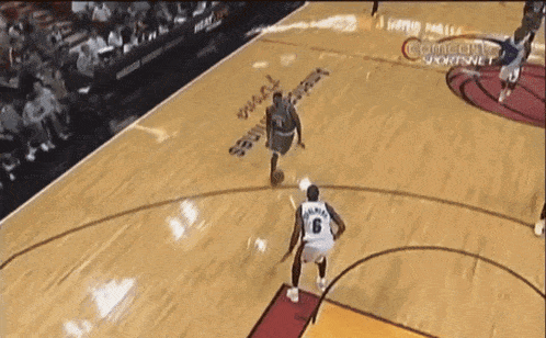 a basketball player wearing a number 6 jersey is dribbling the ball