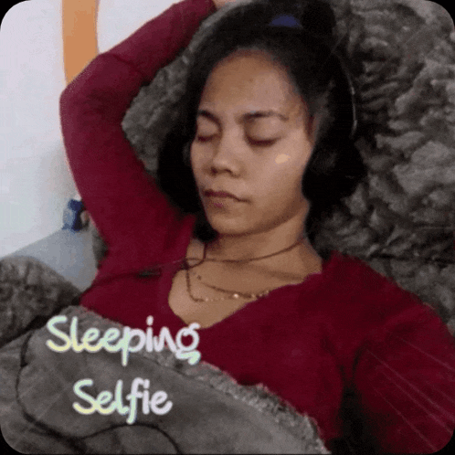 a woman in a red shirt is sleeping with the words sleeping selfie above her