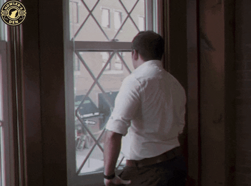 a man in a white shirt looks out a window with an owler 's oem logo in the background