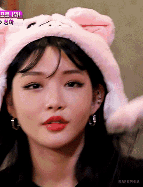 a close up of a woman wearing a pink hat with bunny ears