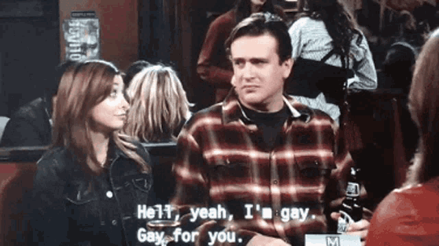 a man in a plaid shirt talks to a woman in a crowd