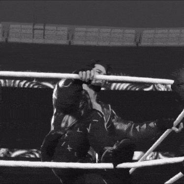 a black and white photo of a man in a leather jacket with his arms outstretched