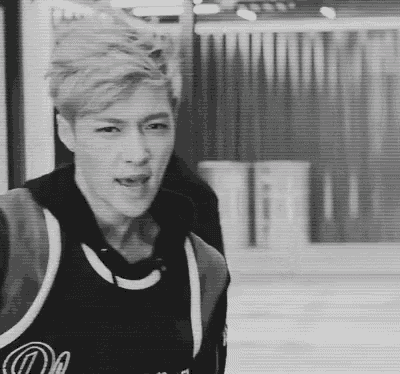 a black and white photo of a man wearing a basketball jersey and headphones .