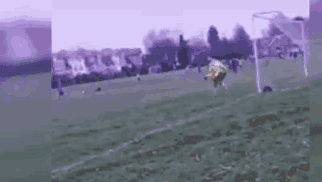 a group of people are playing soccer on a field with buildings in the background .