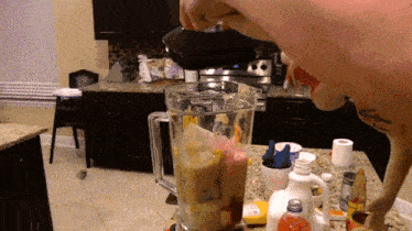 a person is pouring liquid into a blender that has a label that says ' strawberry ' on it