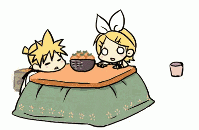 a boy and a girl are sitting at a table with a bowl of food on it
