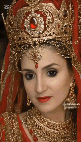 a close up of a woman wearing a crown and gold jewelry .