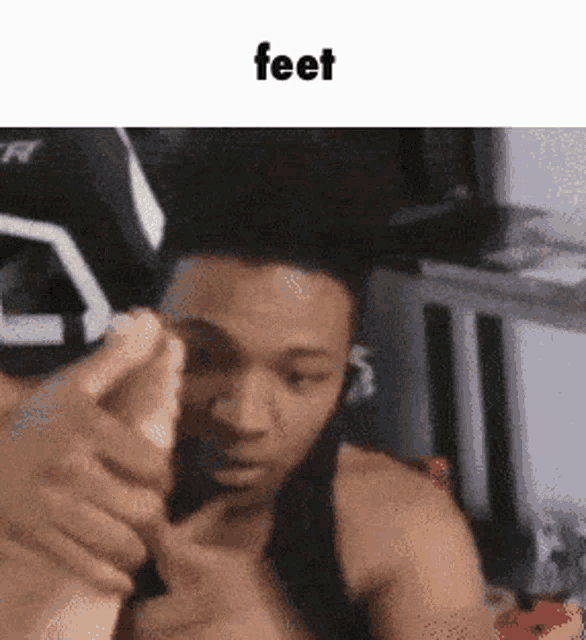 a man is holding another man 's foot in front of his face with the caption feet