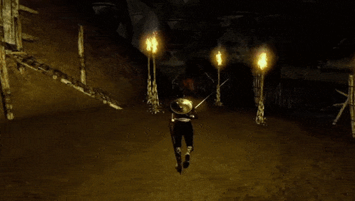 a man is walking down stairs in front of a fire .