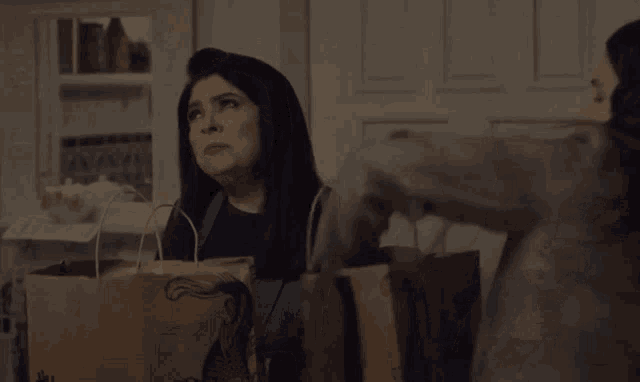 a woman is holding a brown bag that says ' sally ' on it