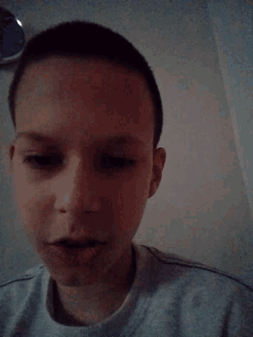 a close up of a person 's face with a gray shirt on