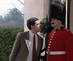 a man in a suit and tie is kissing a man in a red uniform