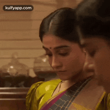 two women are standing next to each other in a kitchen .