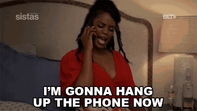 a woman on a bed talking on a cell phone and says i 'm gonna hang up the phone now