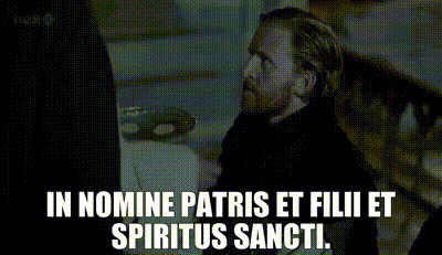 a man with a beard is talking to another man with the words in nomine patris et filii et spiritus sancti