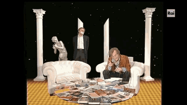 a man sits in a chair with a pile of magazines in front of him and the words rai on the bottom right